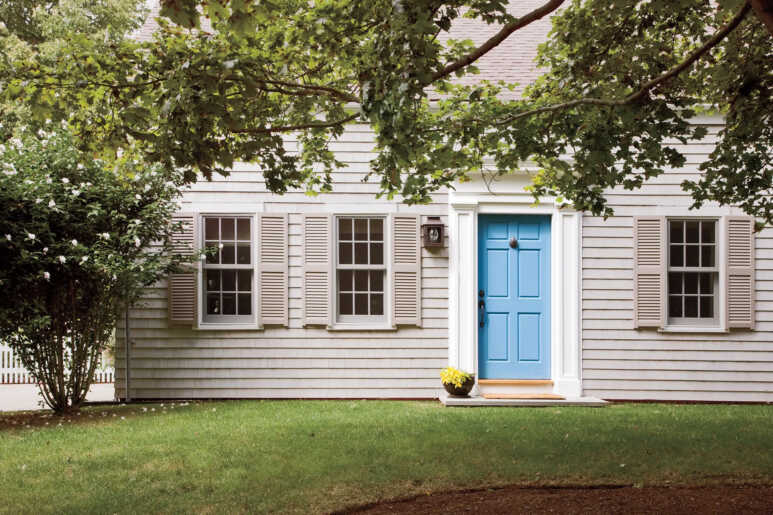 A Caribbean blue front door lightens the ranch-style house