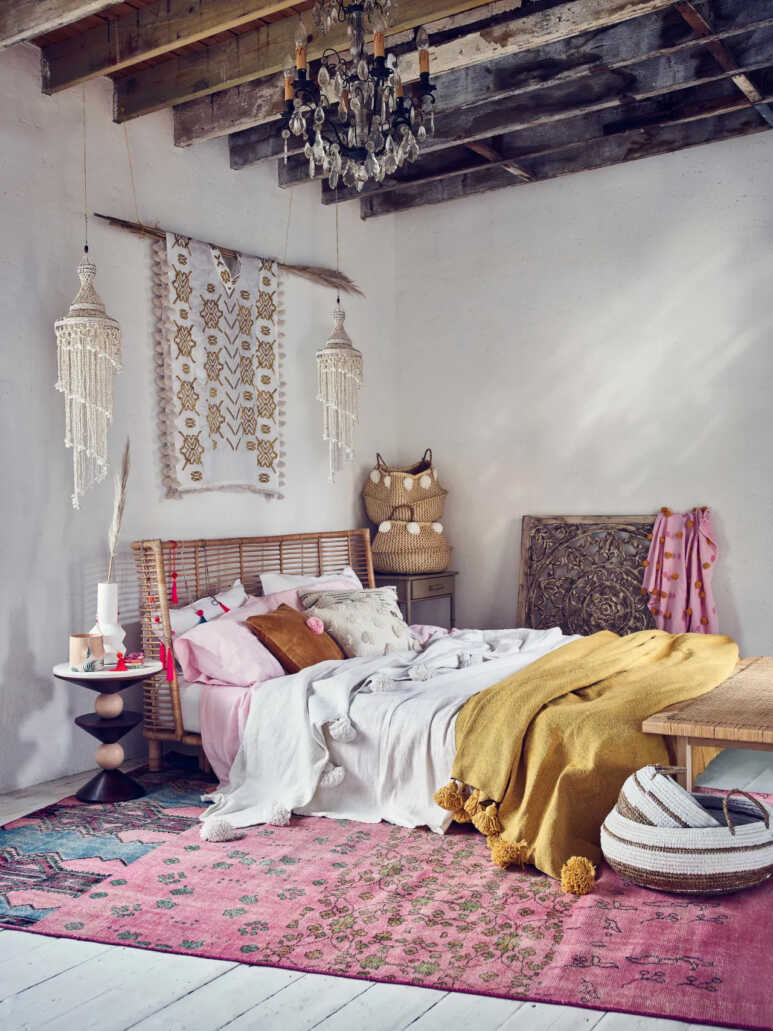 A bedroom idea to create a bohemian-inspired look with white wall and pink patterned rug