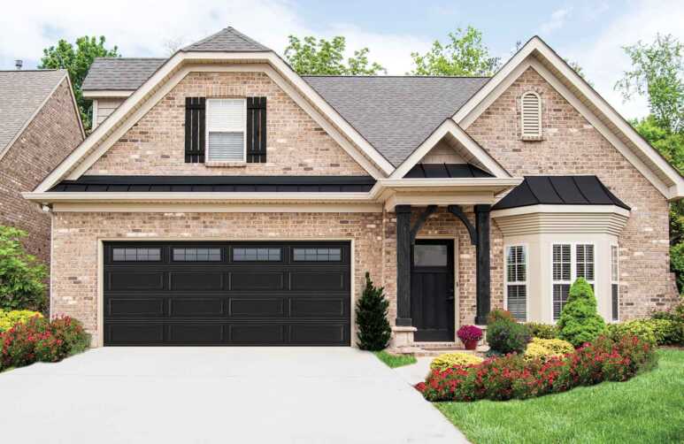 A black garage installed in a brick exterior makes the house look classy
