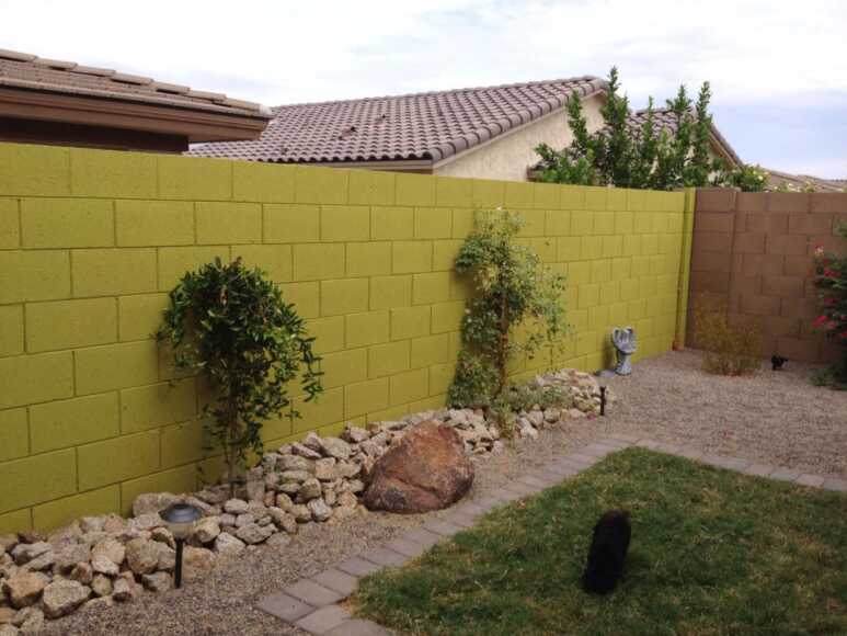 A fresh backyard with lime green wall-painting for the cinder blocks