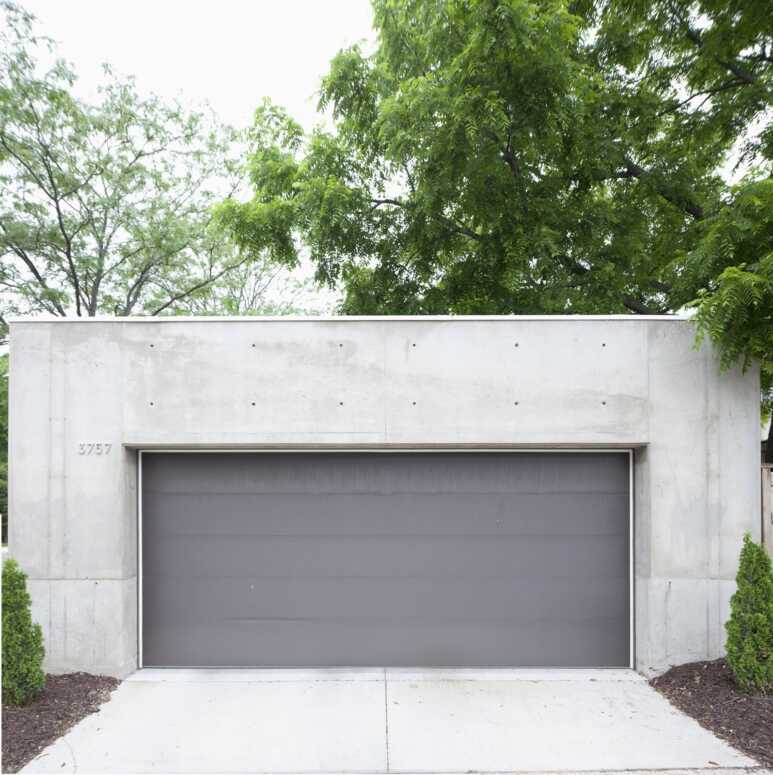 A gray tilt-up and over door complements the contemporary stand-alone garage