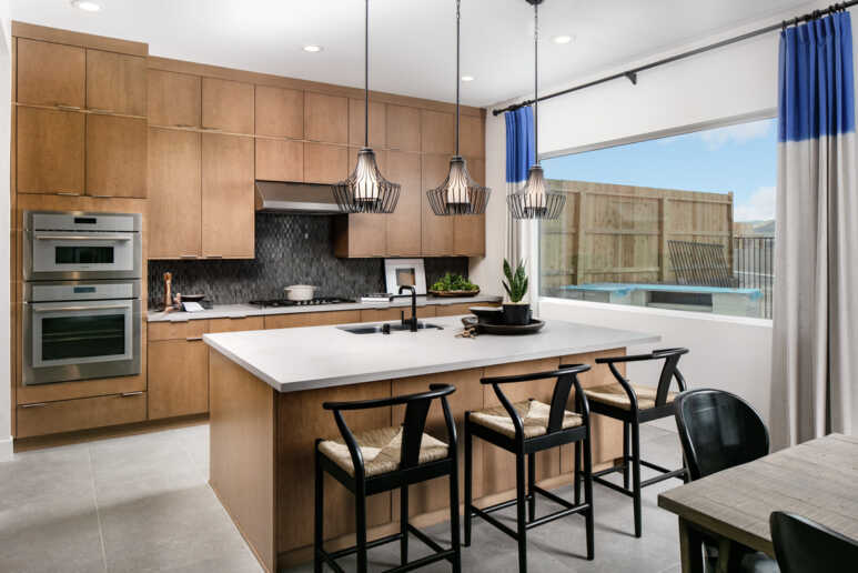 A minimalist kitchen with black modern curved back dining chairs and white kitchen island top