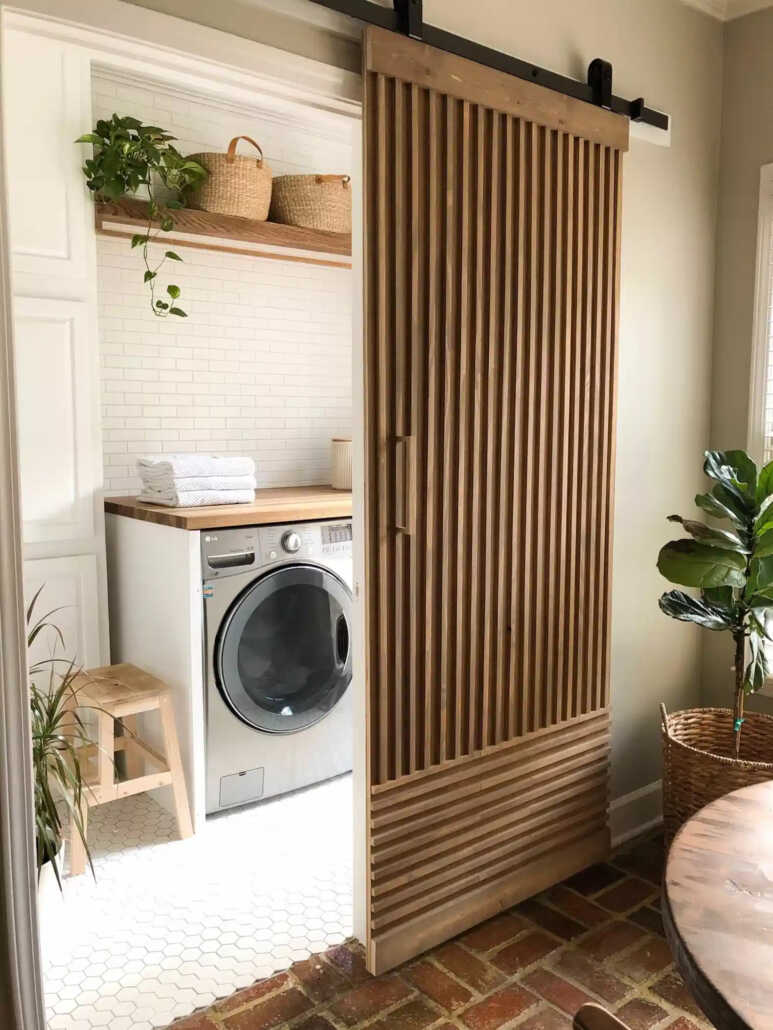 A single barn door with wooden slats for a natural and modern laundry room