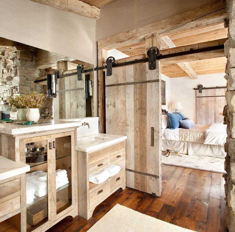 A wood barn door nicely matched with wooden furniture in a rustic stone house