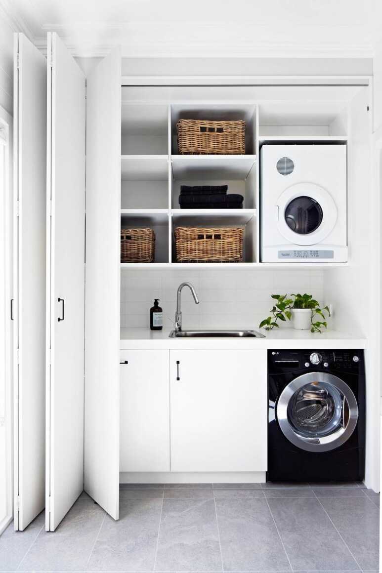 An all-white laundry closet with a folding door makes the surroundings look bright and clean
