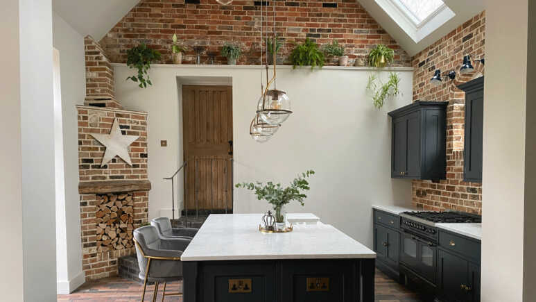 Black and white kitchen island enhances the homely look of the brick veneer interior kitchen