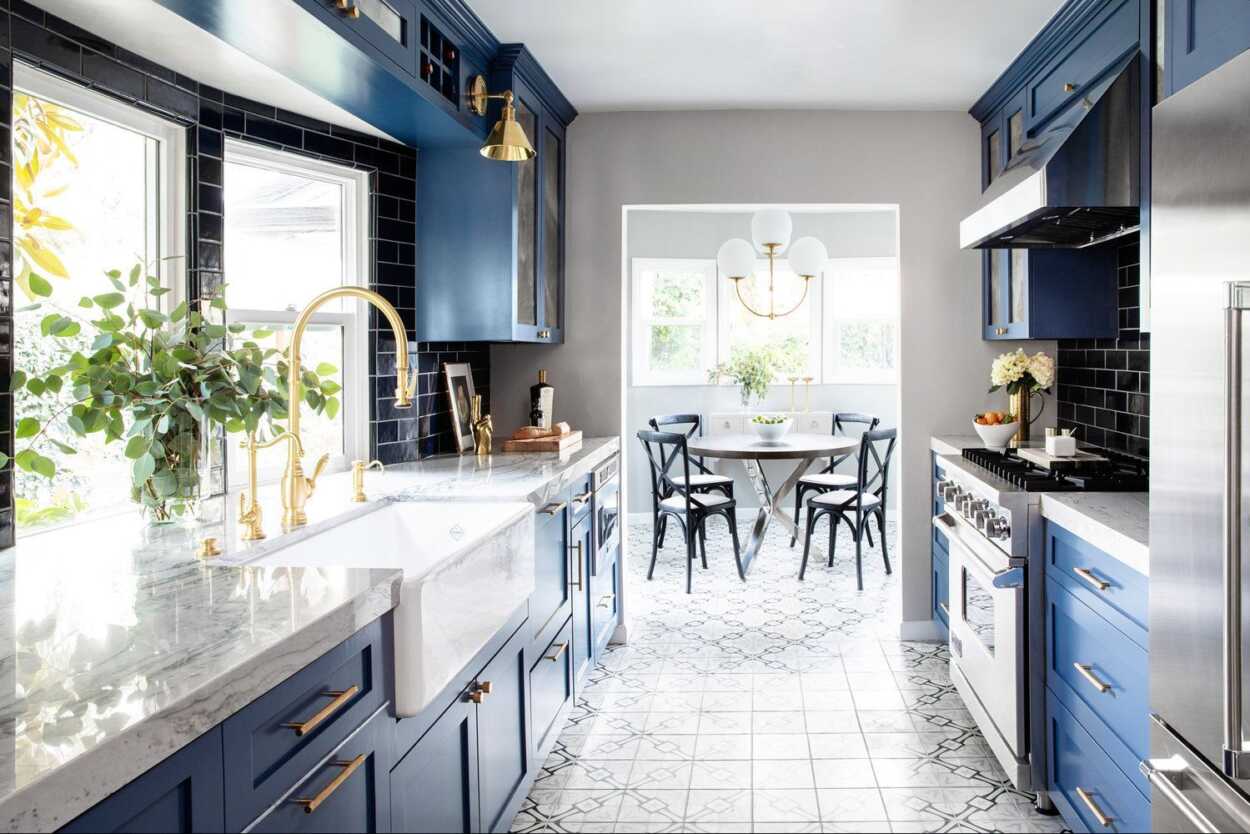 Combining navy blue kitchen cabinets with patterned walls and flooring tiles for a unique and chic kitchen