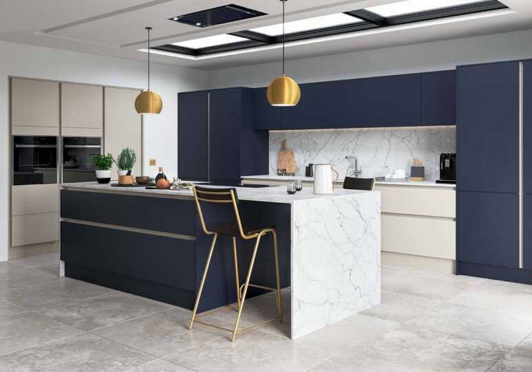 Navy blue kitchen cabinets combined with cream cabinets and marble decoration to enhance a contemporary kitchen with skylight