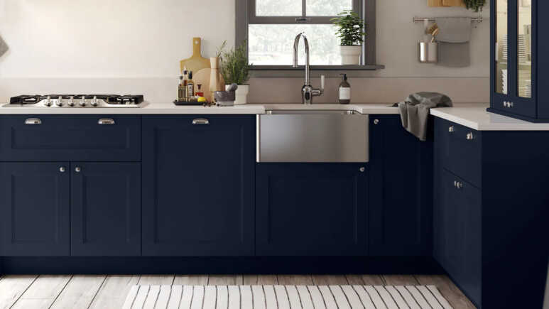 Navy blue kitchen cabinets with stainless steel details to enhance a bright and elegant view