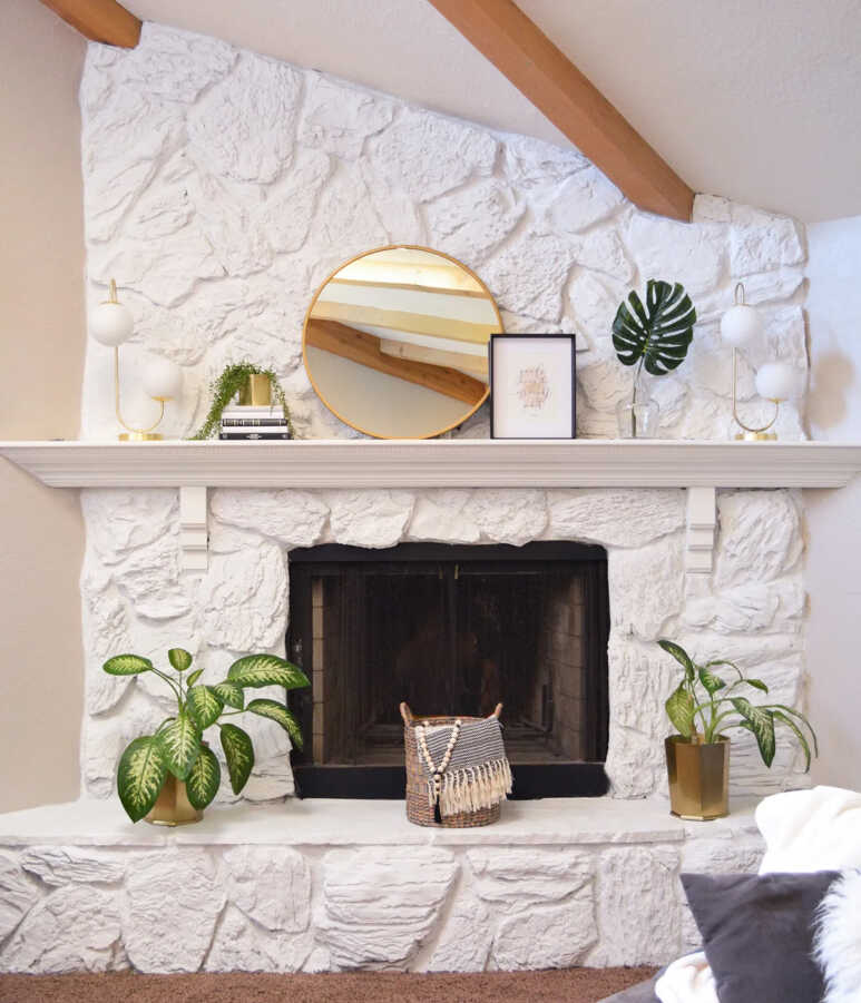 Stone fireplace painted in all white with some greens creating a clean and fresh look