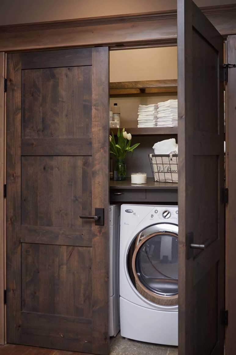 The Wooden double door matched with a wooden cabinet and shelf for a classic laundry closet