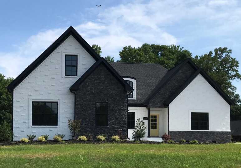 The combination of dark grey and white painted stone materials creates a new farmhouse look