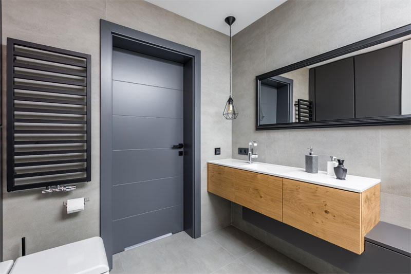 Using a dark gray color for the PVC door to help create a spacious vibe in a small bathroom