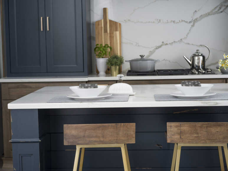 Worn-out navy blue kitchen cabinets paired up with wooden and marble elements for a rustic kitchen