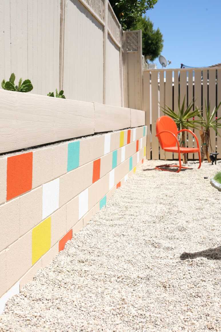 Zooming in the orange bright yellow white and coastal blue wall painting creates the summer feels in cinder blocks